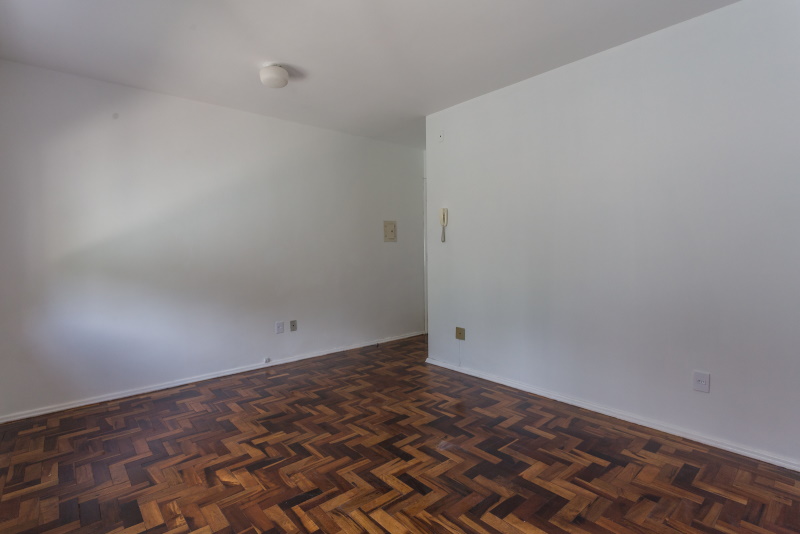 Ambiente vazio com piso em parquet e paredes brancas