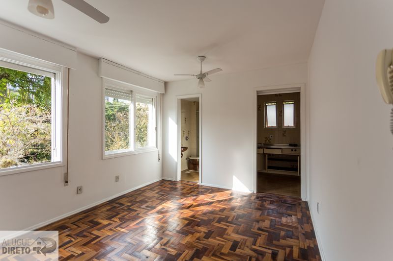 Sala em ângulo diferente mostrando acesso ao banheiro e à cozinha