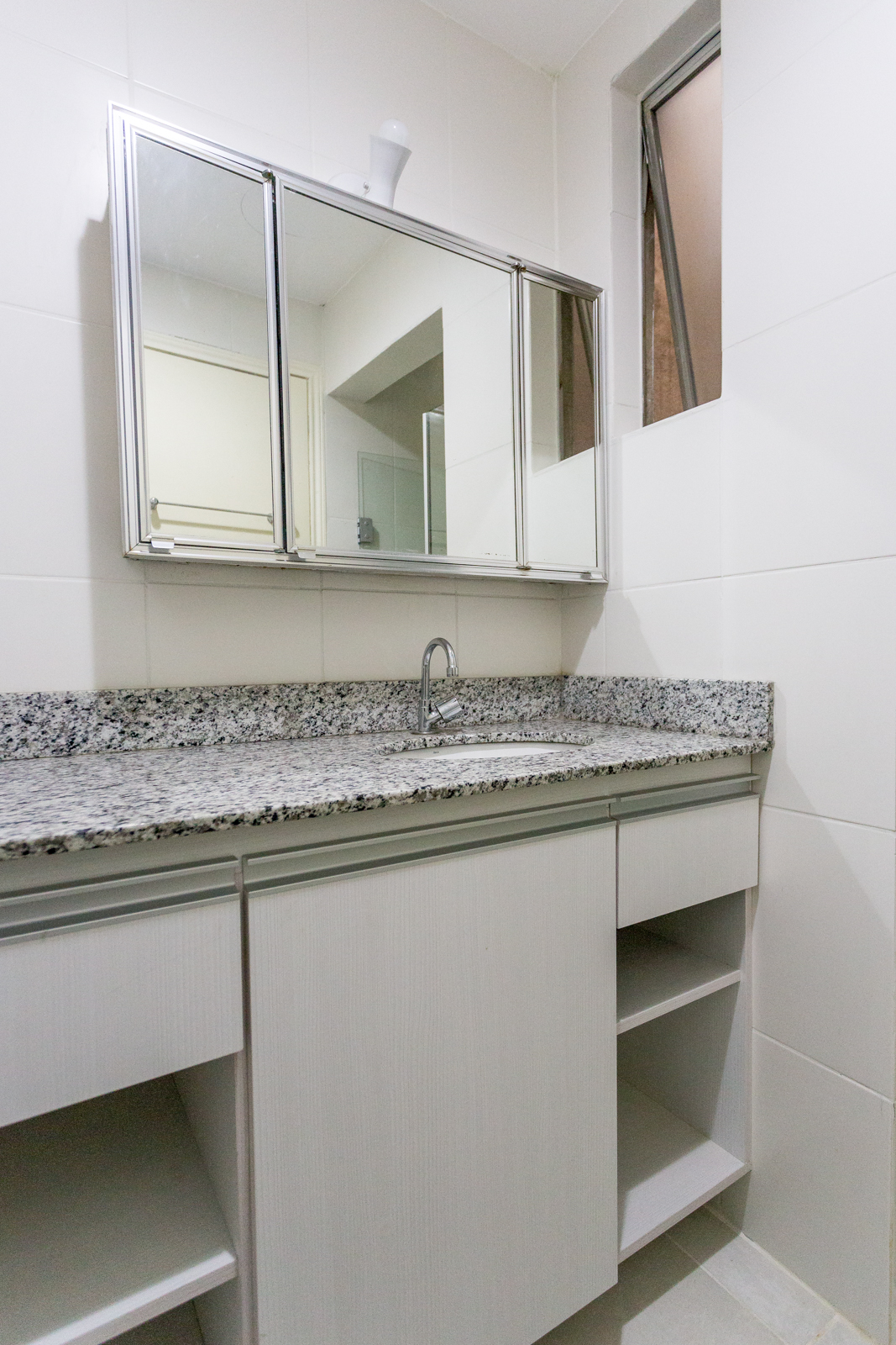 Banheiro com bancada de granito e espelho