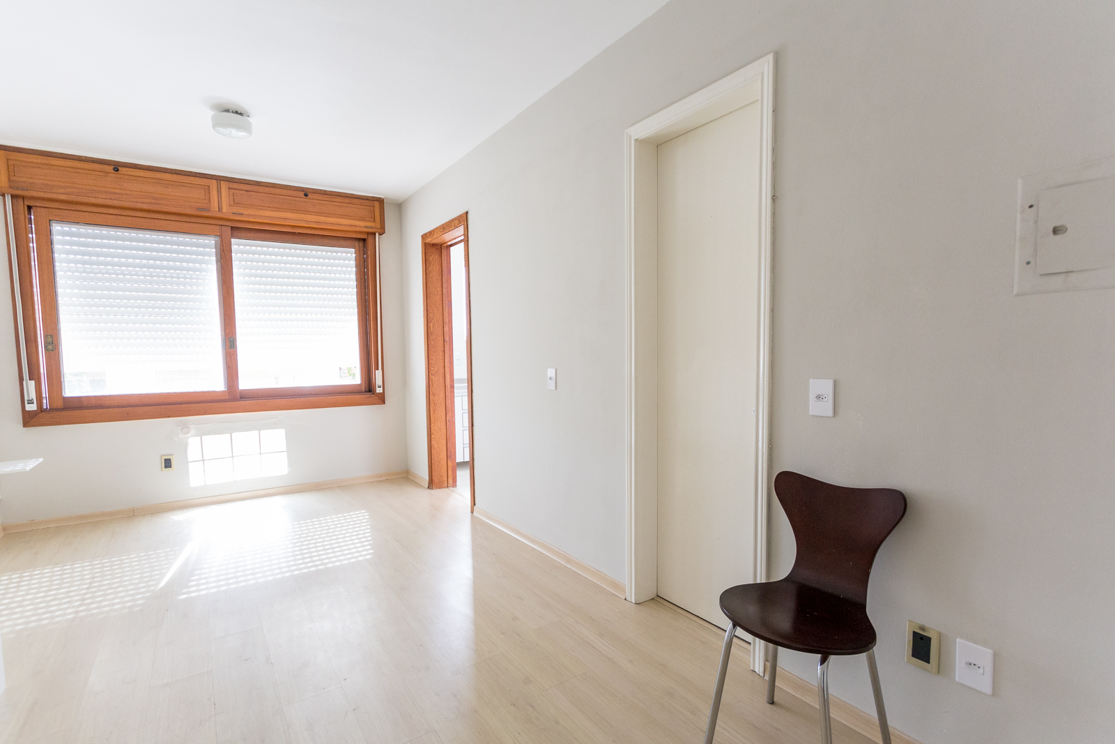 Sala com janela de madeira e piso laminado claro